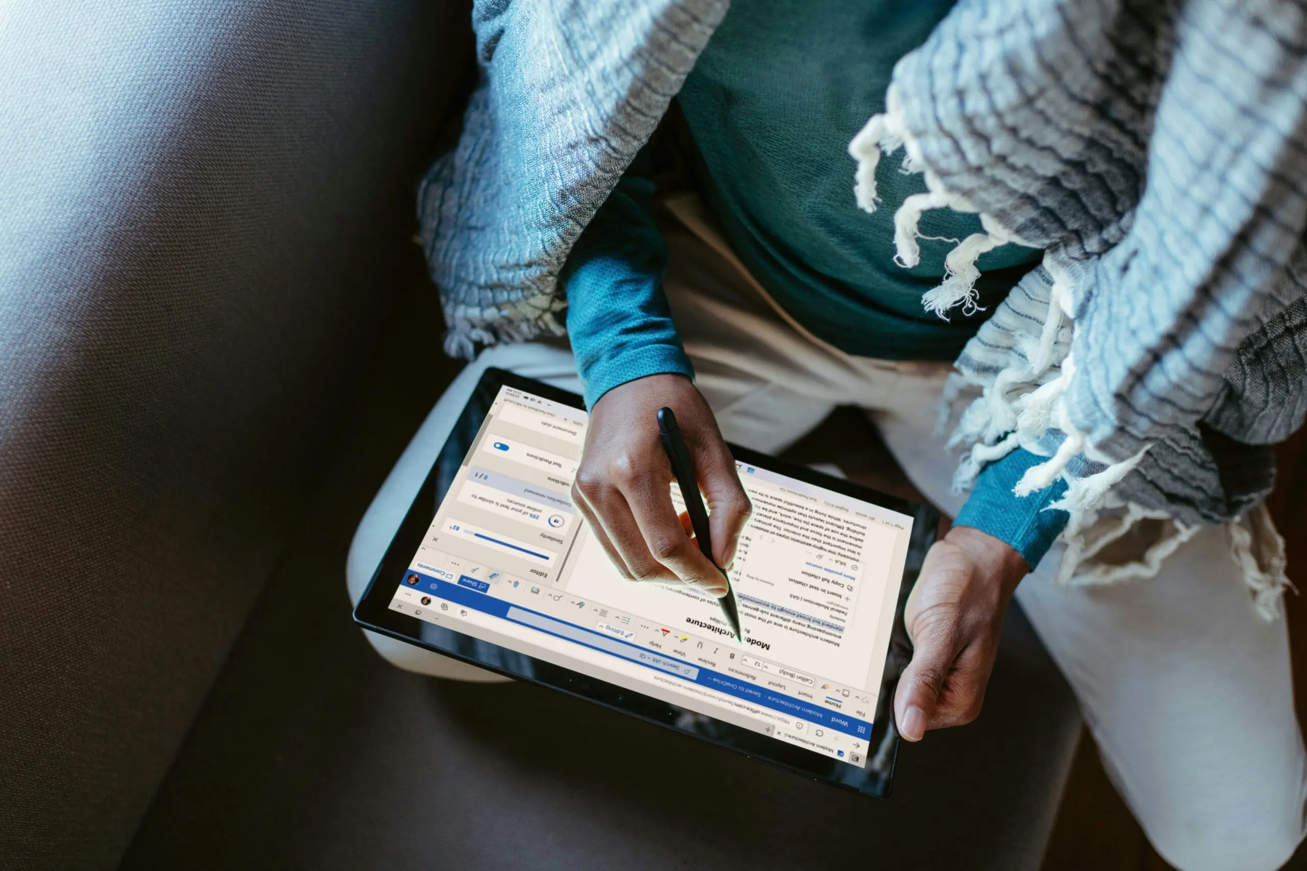 Overhead shot of person editing a Microsoft Word document using a tablet.