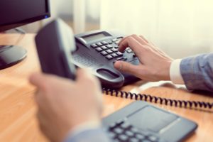 Businessman dialing on VOIP Phone 