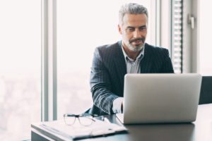 Small business owner on laptop using ACT! Contact Management Software 