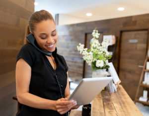 Woman working at a spa talking on the phone with a VoIP system 