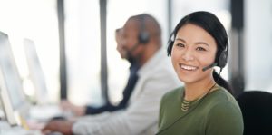 Smiling business woman working an IT help desk 