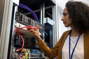 Internal IT help desk: IT engineer in the server room connecting cables