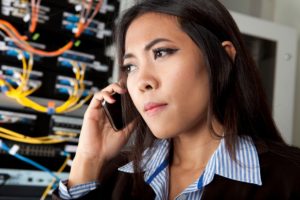 Woman in a server room on phone preparing a backup disaster recovery plan