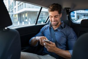 Business man in a car using VOIP to make and receive calls from the same number