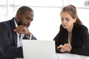 Two collegues diceussing customer support challenges in a IT help desk meeting