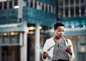 Business woman on the go using her mobile phone to resolve problems with customer support