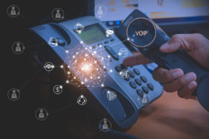 Hand of man using ip phone with flying icon of voip services and people connection, voip and telecommunication concept