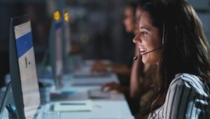 A woman provides customer service at an IT help desk 