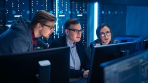 Three IT managers work together on technical projects 