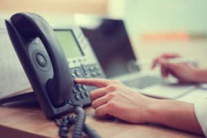 Employee using a company VOIP system while working on a laptop. 