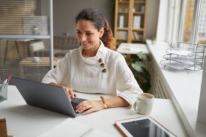 Solopreneur using a laptop to research for her business' backup recovery plan