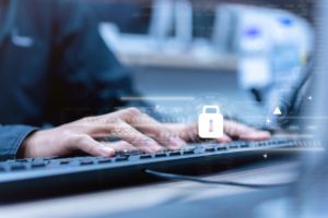 Employee's hands typing on a computer keyboard, showing a concept of company cybersecurity using Perch Security solutions. 