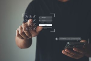 Employee holding a smartphone while entering a multi-factor authentication code for his personal data. 