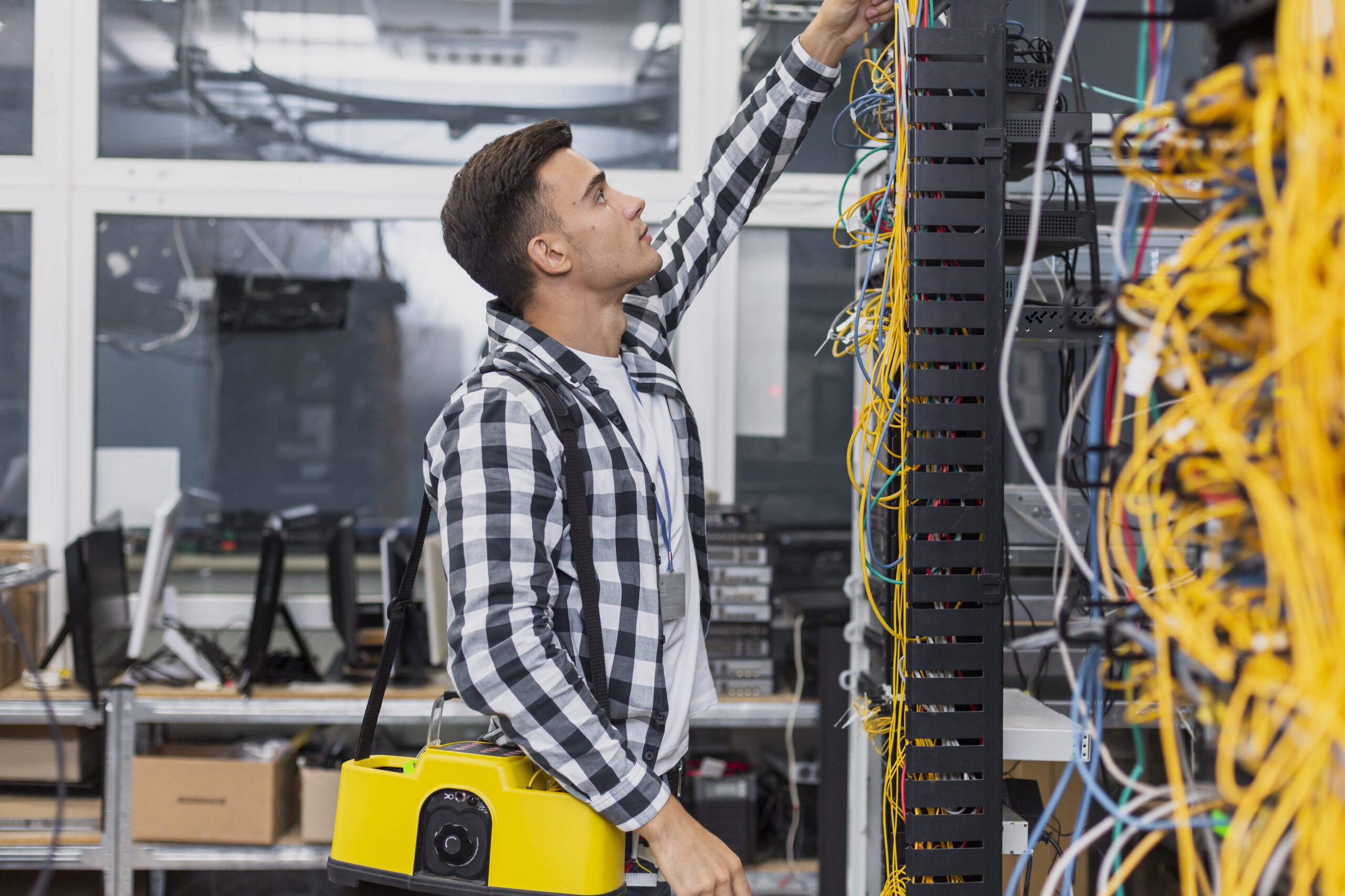 Network technician installing cables on a structured cabling rack