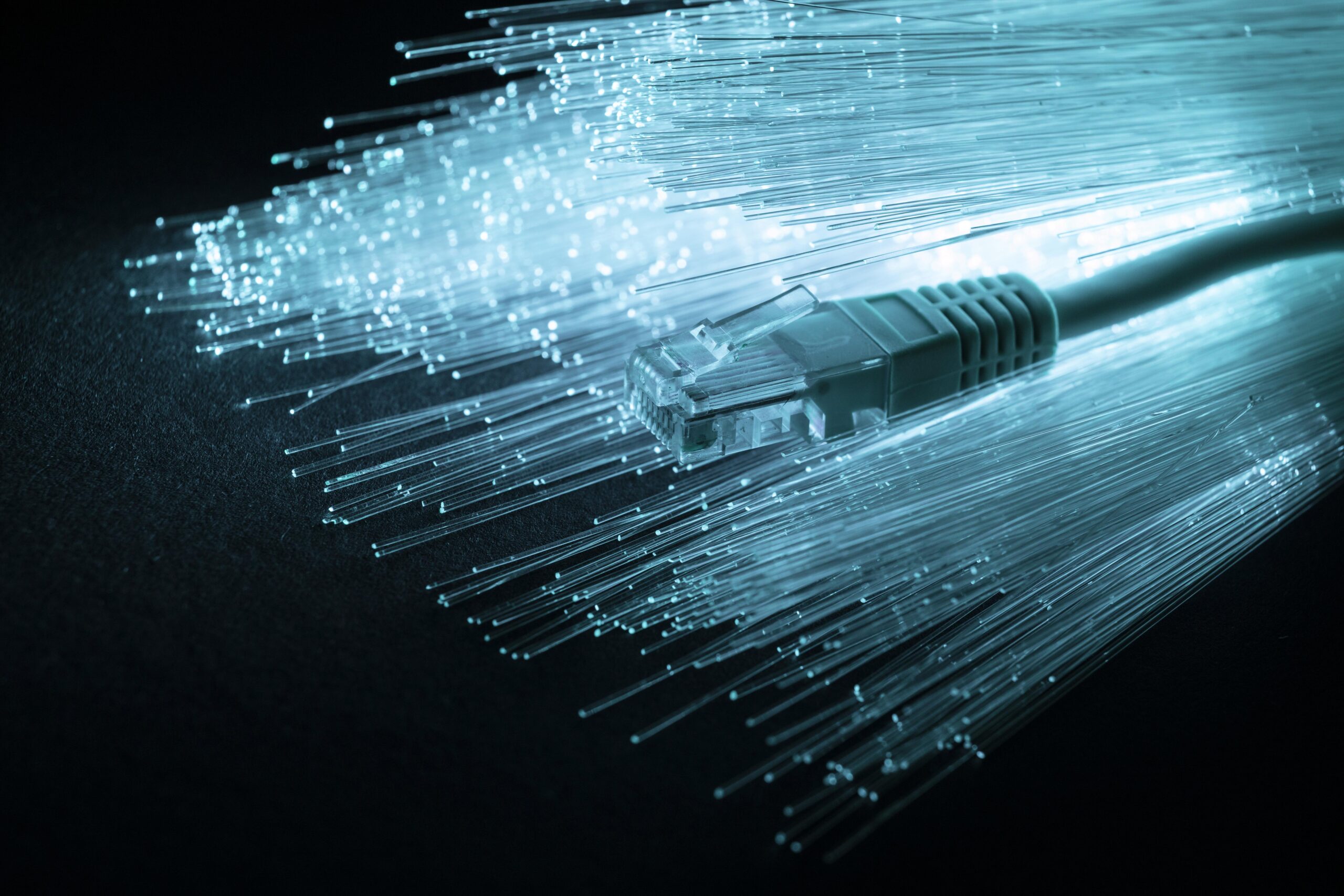 Glowing fiber optic cable strands on a dark background